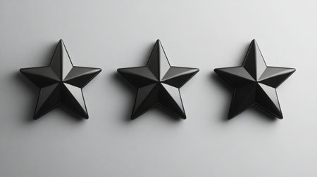 Three sleek black stars arranged in a row against a minimalistic gray backgroundの素材