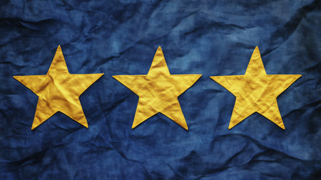 Three gold stars on a blue fabric backgroundの素材