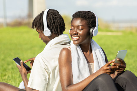 Enjoying music together in a sunny park while relaxing on a warm day