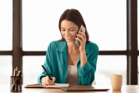 Portrait of smiling manager making phone call at officeの写真素材
