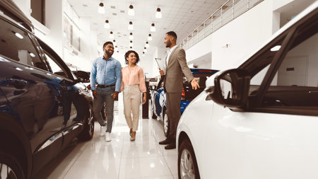 Car Sales Manager Showing Auto To Buyers In Dealership Store