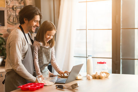 Video Recipe. Happy Father And Little Daughter Using Laptop In Kitchenの写真素材