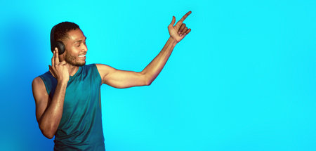 African Sportsman In Earphones Dancing Enjoying Music Over Blue Background