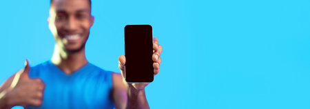 Unrecognizable Black Sportsman Showing Smartphone Screen Gesturing Thumbs-Up In Studio