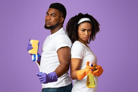 On Guard Of Cleanliness. Serious Black Couple Posing With Cleaning Suppliesの写真素材