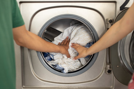 Couple doing laundry together in a modern washing machine at homeの写真素材