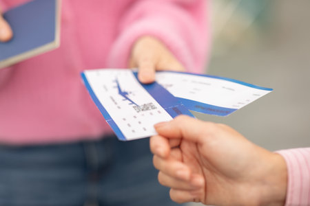 Travelers exchanging boarding passes and passports at an airport counterの写真素材