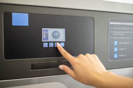 User interacts with a modern touch screen control panel in a facilityの写真素材