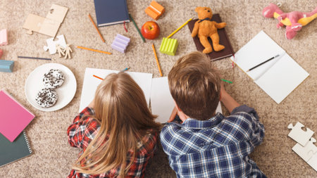 Unrecognizable Brother And Sister Drawing Together Lying On Floor
