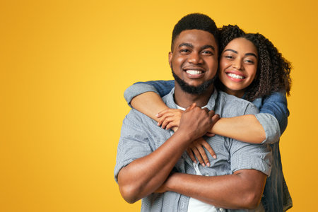 Portrait of black couple in love hugging and smiling at cameraの写真素材