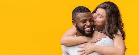 Loving Woman Kissing And Hugging Her Afro Boyfriend From Backの写真素材