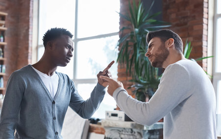 Colleagues having fight at workplace, two men fighting at job