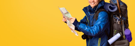 Backpacker following map, smiling over orange background