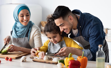 Young Arab Father Showing How To Chop Mushrooms To His Little Daughterの写真素材