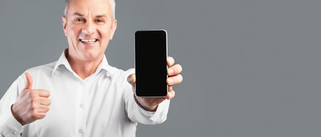 Smiling man showing mobile phone with empty screen