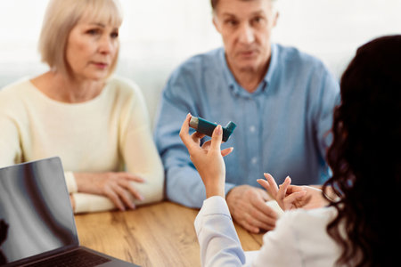 Physician giving asthma inhaler to elderly couple