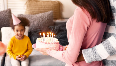 Birthday of little girl. Parents give cakeの写真素材