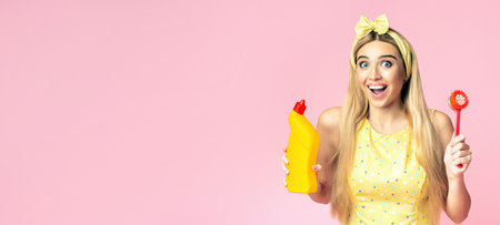 Blonde girl holding brush and bottle with detergentの写真素材