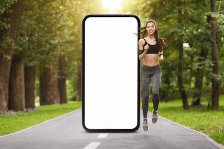 Young woman jogging on a park path with a large empty smartphone display