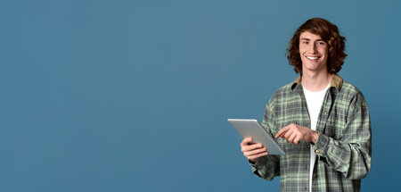 Communicating online. Portrait of millennial hipster using tablet computer on color backgroundの写真素材