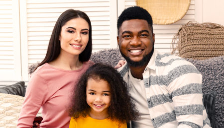 Smiling young international family with little daughter