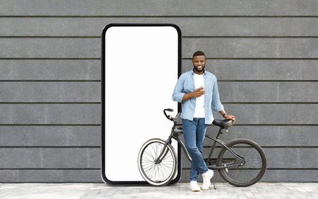 Man leaning against a bicycle beside a blank smartphone-shaped wall display
