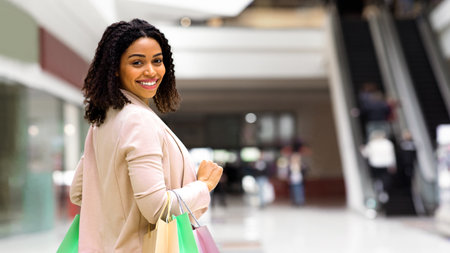 Shopping Weekend. Smiling Black Woman Walking In Department Store With Paper Bagsの写真素材