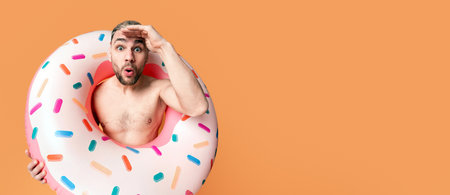 Naked guy in inflatable ring looks into distanceの写真素材