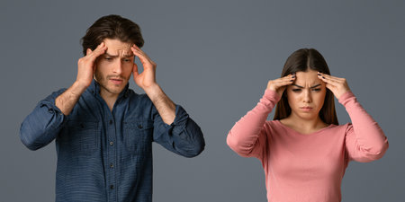 Asian young couple having headache cause of fight, touching their heads, panorama with copy spaceの写真素材