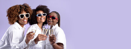 African Women Clinking Glasses Celebrating Wearing Sunglasses Over Purple Backgroundの写真素材