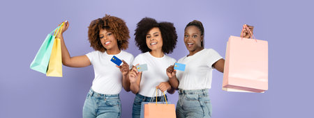 Three friends enjoying a shopping trip with colorful bags and cardsの写真素材