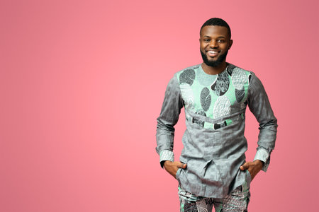 Confident black man smiling on pink backgroundの写真素材