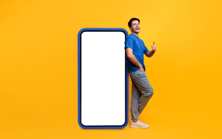 Guy leaning on white blank smartphone screen showing thumbs up