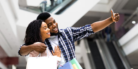 Positive Black Spouses Shopping In Department Store And Taking Selfie On Smartphoneの写真素材