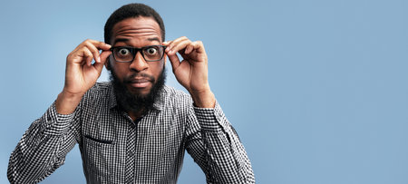 Surprised african american guy touching his eyewearの写真素材