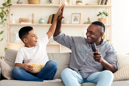 Black Boy And His Happy Grandpa Giving High Five To Each Otherの写真素材