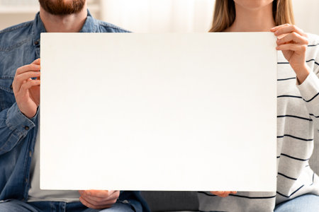 Man and woman holding blank placard at home, empty spaceの写真素材