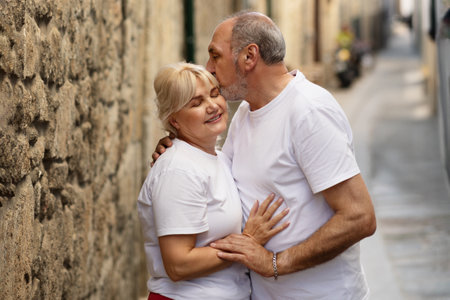 Couple sharing a loving kiss in a quiet stone alleyway in summerの写真素材