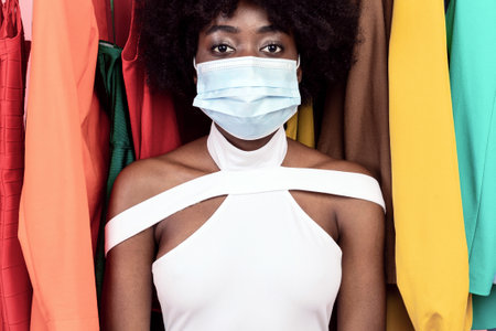 Portrait Of Black Female Wearing Face Mask Shopping, Pink Backgroundの写真素材