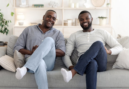 Like Father Like Son. Happy Man Sitting In Similar Pose With Dadの写真素材