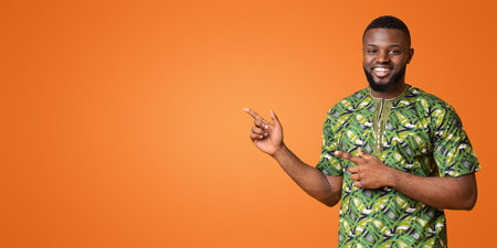 Positive black man pointing at copy space over yellow