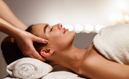 Young woman receiving professional head massage at spaの写真素材