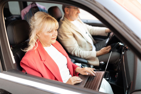 Business meeting on the go in a modern car during daytime commuteの写真素材