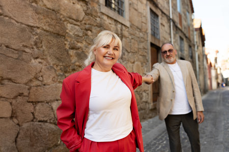 Happy couple enjoying a stroll down a charming cobblestone street in summerの写真素材