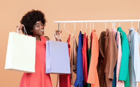Excited African Lady Showing Shopper Bags Standing In Studio, Verticalの写真素材