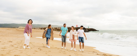 Family enjoying a beach walk together during a cloudy day by the ocean