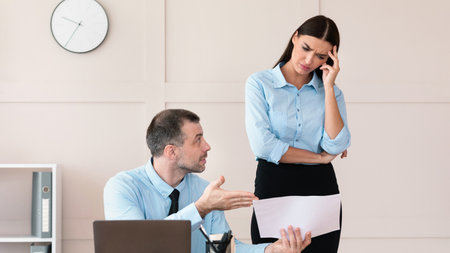 Discontented Businessman Giving Warning Female Employee For Incompetence In Officeの写真素材