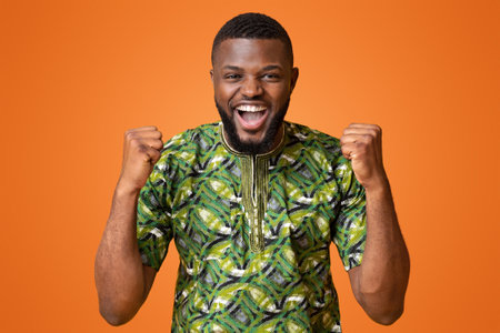 African guy expressing happiness over yellow backgroundの写真素材