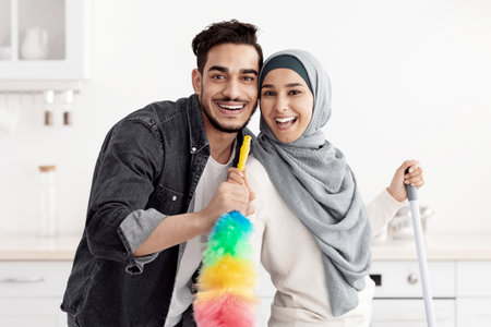 Happy arab lovers enjoying house-keeping at homeの写真素材
