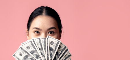 Big Profit. Happy Young Asian Woman Covering Face With Dollar Cash Fanの写真素材